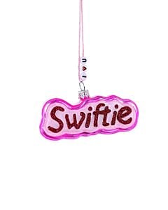 Swiftie ornament features the word “Swiftie” displayed in bold red and pink lettering for a vibrant fan-inspired holiday accent. This Cody Foster & Co collectible adds pop culture personality, playful color, and music lover charm to Christmas décor.