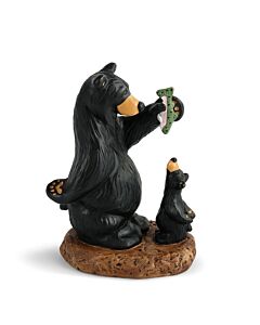 Hand-cast resin figurine depicting a small black bear standing on its hind legs, reaching up to a larger bear holding a fish, capturing a playful moment of a cub begging for a treat; designed by Jeff Fleming.
