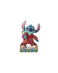 Whimsical Jim Shore figurine depicting Stitch in festive pajamas and snowman slippers, joyfully holding a candy cane. Perfect for celebrating the magic of the holiday season with Disney charm.