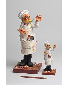 A playful mini figurine of a chef in a white uniform and tall hat, proudly tasting a gourmet dish with exaggerated flair, in his splattered apron.