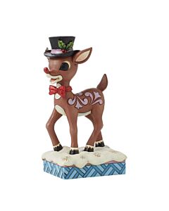 Rudolph the Red-Nosed Reindeer struts his festive flair in a dapper top hat adorned with mistletoe and a charming red bow tie, brought to life with Jim Shore's signature rosemaling details and playful holiday spirit.