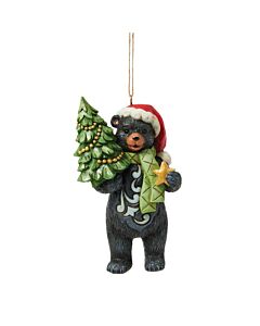 A playful black bear ornament holds a miniature decorated Christmas tree, bringing woodland charm to the holiday season. Dressed in a Santa hat and festive scarf, the bear clutches a star, ready to spread cheer.
