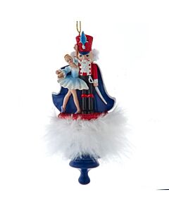 A festive Kurt Adler ornament featuring the Nutcracker Prince and Clara, with Clara wearing a charming holly-adorned hat. This collectible captures the magic of the Nutcracker ballet in vibrant colors and intricate holiday detail.