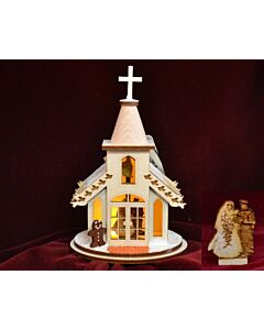 A whimsical, snow-dusted wedding chapel. This charming Ginger Cottage features intricate details and is designed to light up when a Christmas tree bulb is inserted, creating a warm and cozy glow perfect for holiday decor