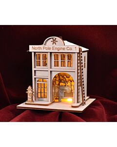 A charming, snow-dusted firehouse ornament from the Ginger Cottages collection. This quaint design captures the magic of the North Pole, complete with a festive glow when illuminated by a Christmas tree light.