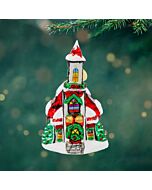 A snow-covered chapel ornament glows with serene holiday charm, surrounded by delicate holly accents. Its peaceful presence evokes warmth, hope, and the quiet magic of the season.