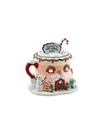 Festive Santa mug-shaped café building with whimsical holiday details, featuring a marshmallow man greeter at the door and a cozy spot for elves to unwind.