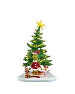 The Grinch, Max, and Cindy-Lou Who stand joyfully in front of a decorated Christmas tree, singing together in celebration of the holiday spirit.