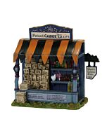 Whimsical Halloween kiosk decorated with spooky signage and magical details, offering spells and potions to curious passersby.