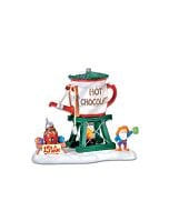 Festive village accessory featuring a tall hot chocolate dispenser tower with cheerful holiday details and a snowman-shaped base.