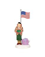 Department 56’s Play Ball accessory features Aunt Bethany pausing beneath the flagpole to say grace in a whimsical holiday moment. Capturing her quirky personality, this piece adds charm and humor to any Christmas Vacation Snow Village display.