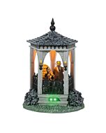 Miniature scene featuring Morticia and Gomez Addams in a shadowy, gothic-style gazebo under moonlight, capturing their eerie romance.