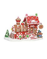 Charming train engine-shaped building decorated for the holidays, serving as a festive supply shop for gingerbread baking essentials at the North Pole.
