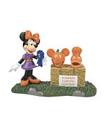 Minnie Mouse joyfully holding a ribbon, about to announce the first-place winner of the pumpkin carving contest.