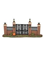 An ornate gate with brick pillars and lanterns, welcoming visitors to the Haunted Mansion with a touch of eerie elegance.