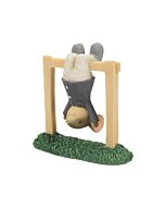 A playful mouse figurine hangs upside down from a playground bar, tiny paws gripping the pole and a delighted smile on its face. The mouse’s eyes sparkle with the joy of childhood mischief, its pink tail curling above its head as it dangles in midair, cap