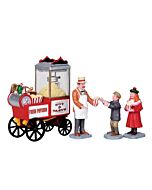 A collectible scene featuring a popcorn seller standing beside a colorful cart, with two eager children nearby. The seller is depicted in a lively pose, capturing the joy of a traditional street food scene.