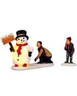 Frosty’s Friendly Greeting set shows a dad admiring a cheerful, illuminated snowman with his son by his side, capturing a heartwarming winter scene.