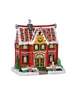 A dazzling, illuminated gingerbread house adorned with shiny sprinkles and a welcoming snowman, radiating holiday cheer.