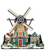 A vibrant windmill stands tall, its blades dusted with snow and trimmed in festive holiday décor. This cheerful landmark brings a touch of rustic charm to the wintry village scene.