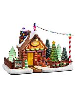 A festive miniature of Lou's Tree Farm glows with colorful lights, inviting visitors to pick their perfect holiday tree. Decorated trees and abundant greenery create a cheerful scene, embodying the spirit of the season.