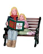 A heartwarming collectible accessory depicting a mother sharing a cherished moment with her daughter on a park bench, as she reads aloud from a festive Christmas storybook