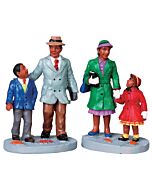 A warmly dressed family walks hand in hand through the snow, heading to church with quiet joy. Their festive outfits and cheerful expressions capture the heart of a holiday tradition.
