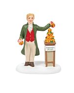 Market vendor presenting oranges decorated with cloves alongside baskets of fruit in a festive Dickensian setting.